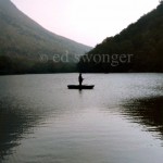 Fisherman in Boat on Mountain Lake